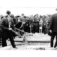 Vintage photo of People gathered around a grave, putting soil over freshly digged grave.