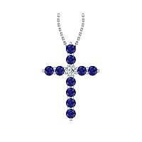 14k White Gold timeless cross pendant set with 10 celestial blue sapphires (1/2ct, AA Quality) encompassing 1 sparkling white diamond, (.055ct, H-I Color, I1 Clarity), suspended on a 18