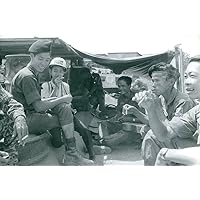 Vintage photo of Vietnamese military men and media having fun talking and smoking cigarettes.