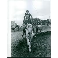 Vintage photo of Princess Yasmin Aga Khan riding a horse with another boy while other kids look on.